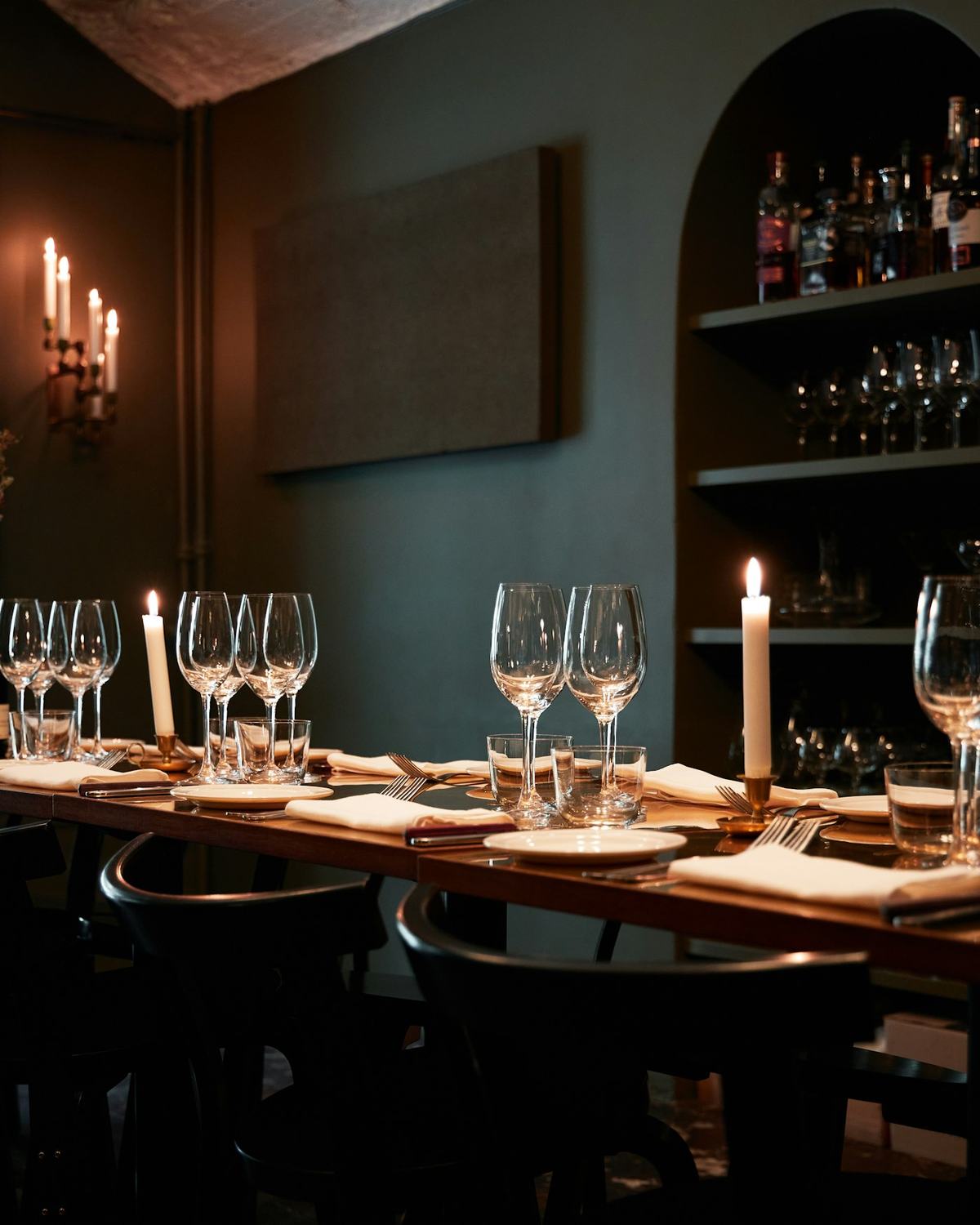 A long table set with candles and glassware