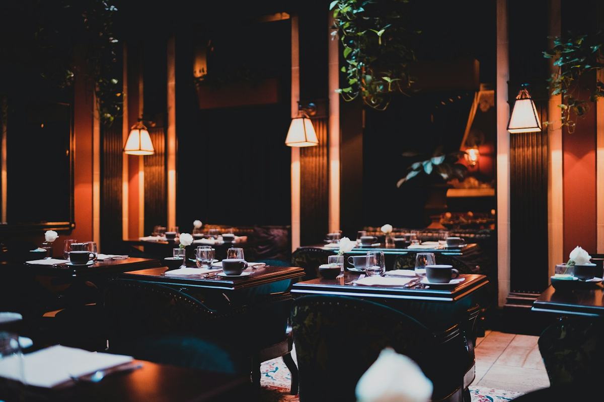 The dining room at Ember & Oak, lamps lit for evening service