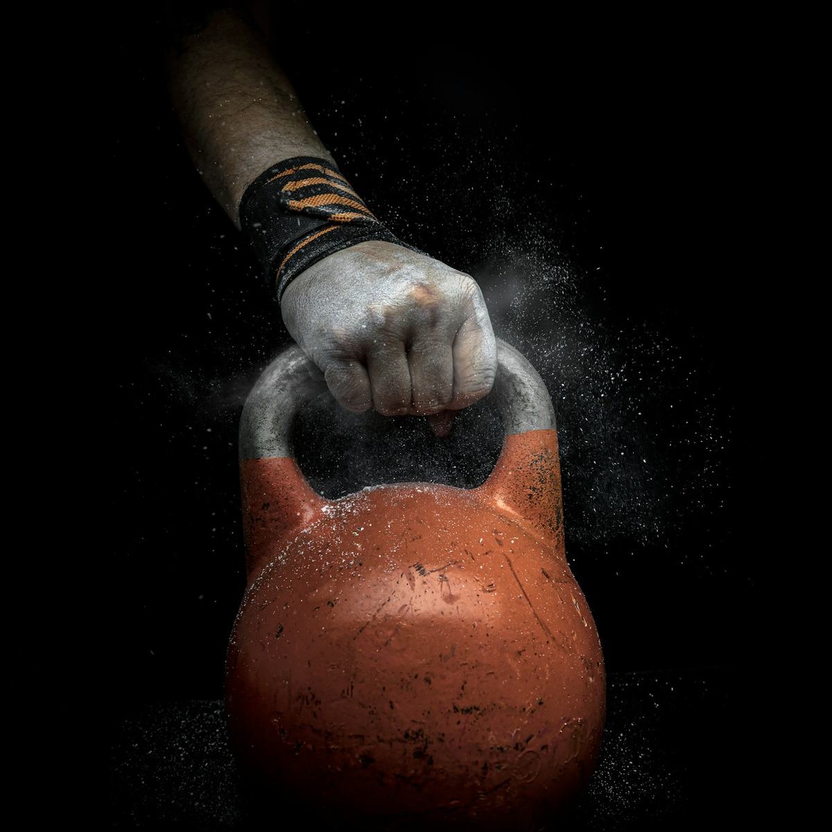 A chalked hand gripping a kettlebell